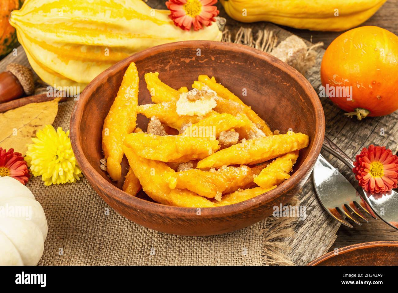 Gnocchi di zucca o gnocchi italiani. Piatto di squash vegetariano sano con formaggio caserario. Decorazioni autunnali con foglie autunnali, coni, zucche intere mature, f Foto Stock