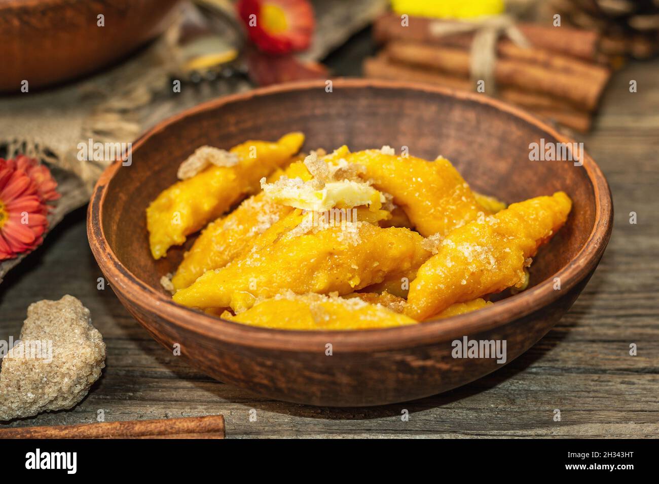 Gnocchi di zucca o gnocchi italiani. Piatto di squash vegetariano sano con formaggio caserario. Decorazioni autunnali con foglie autunnali, zucche intere, fiori e s. Foto Stock