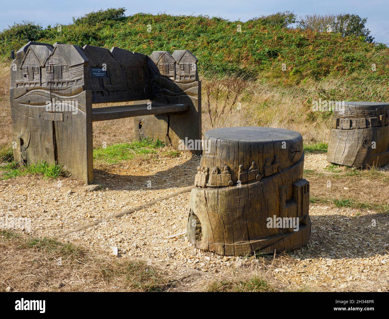 Panca e sgabelli ornati intagliati commemorativi a Hengistbury Head, Dorset, Regno Unito Foto Stock