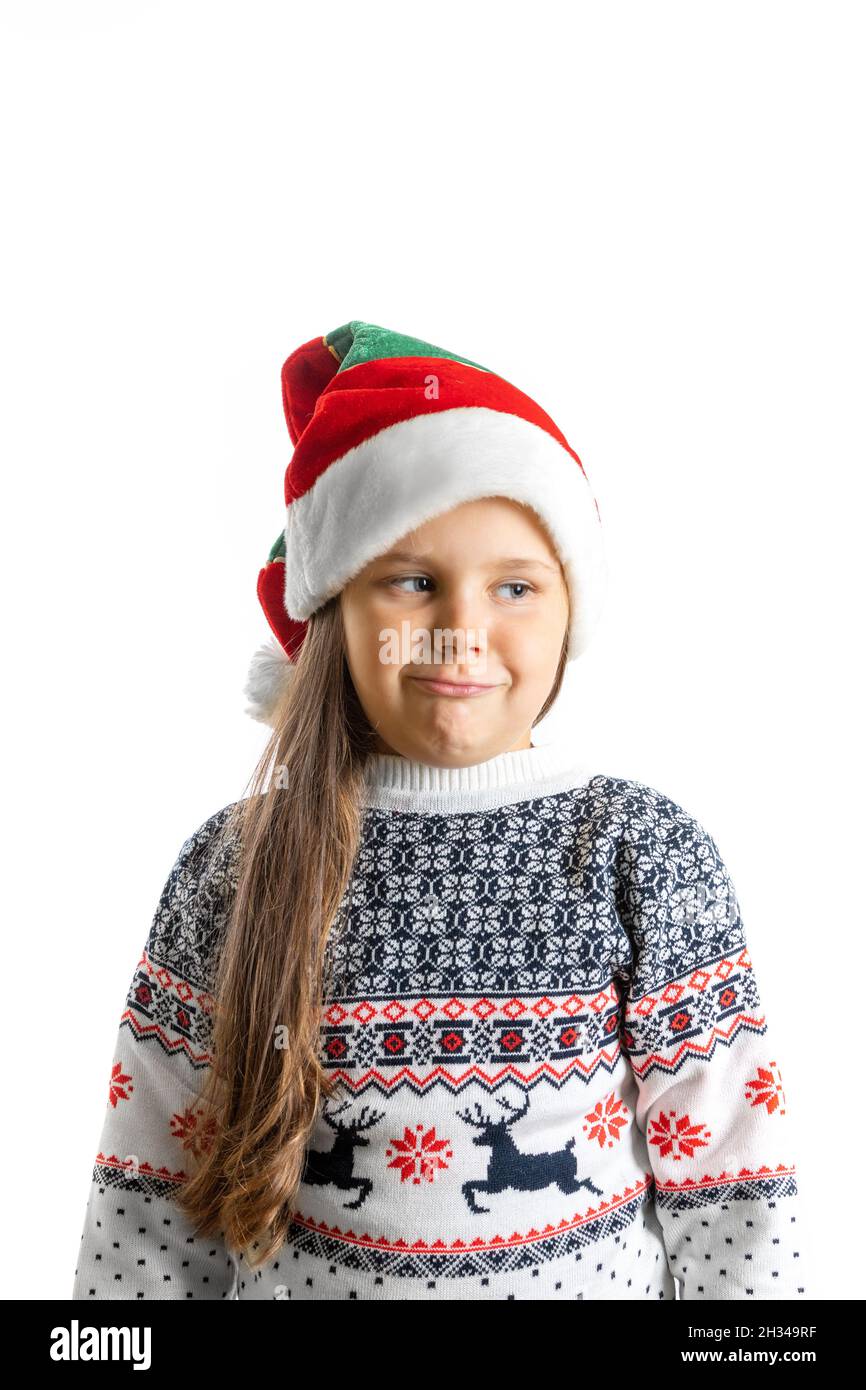 Ritratto di ragazza scontenta, delusa in maglia bianca di Natale maglione con renna e cappello nano con braccia incrociate sul petto, isolato sopra Foto Stock