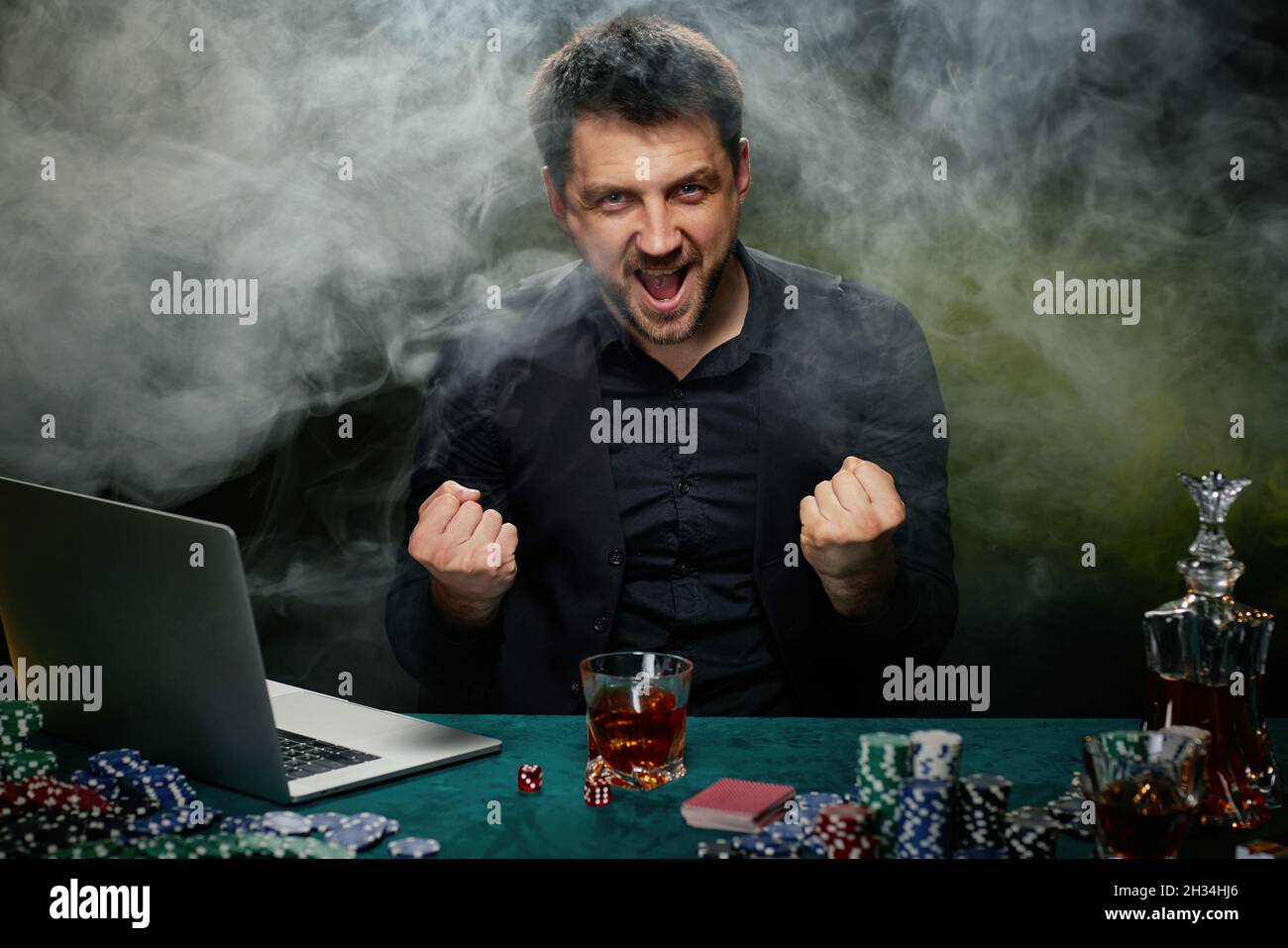 Uomo bearded del giocatore in linea del casino che celebra la vittoria Foto Stock