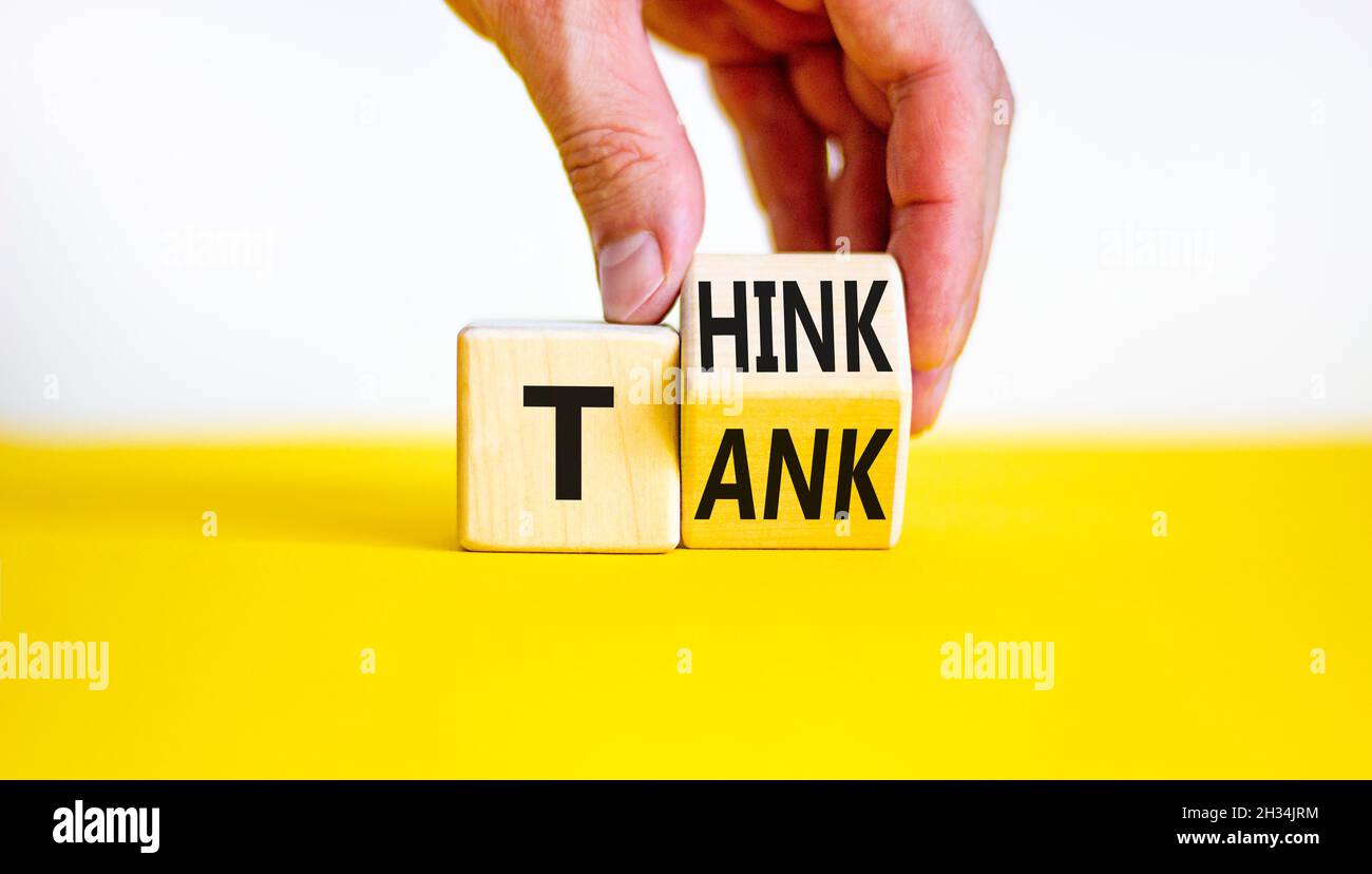 Think Tank. L'uomo d'affari trasforma un cubo di legno e cambia la parola 'serbatoio' in 'pensare' o viceversa. Bella tabella gialla, sfondo bianco, poliziotto Foto Stock