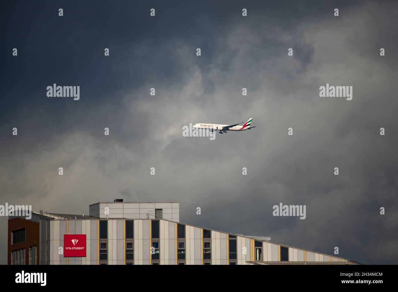 Glasgow, Scozia, Regno Unito. 25 ottobre 2021. NELLA FOTO: Volo Emirates da Dubai che atterra alle finali di Glasgow sopra il sito COP26 della sede della conferenza. Vista del sito COP26 che mostra il fiume Clyde e il porto, con gli edifici del Campus Scottish Event solo 6 giorni fino ai Capi di Stato, Oltre a migliaia di delegati, media e manifestanti si prevede che a breve atterreranno a Glasgow per l'inizio del vertice sul cambiamento climatico che si terrà il 31 ottobre. Credit: Colin Fisher/Alamy Live News Foto Stock