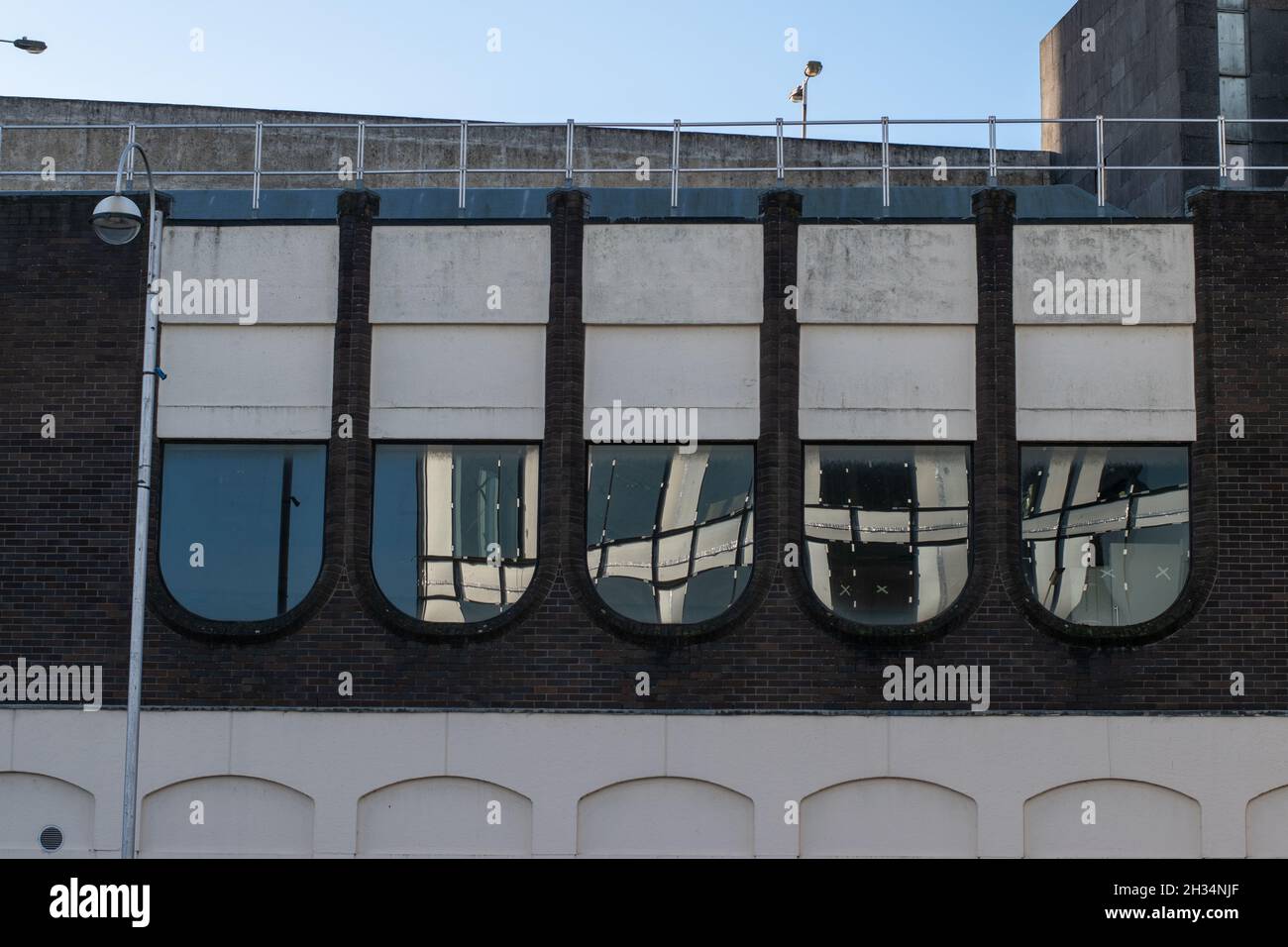 Swindon modernista edificio derelitto architettura riflessione in specchi finestre vecchia e nuova costruzione Foto Stock