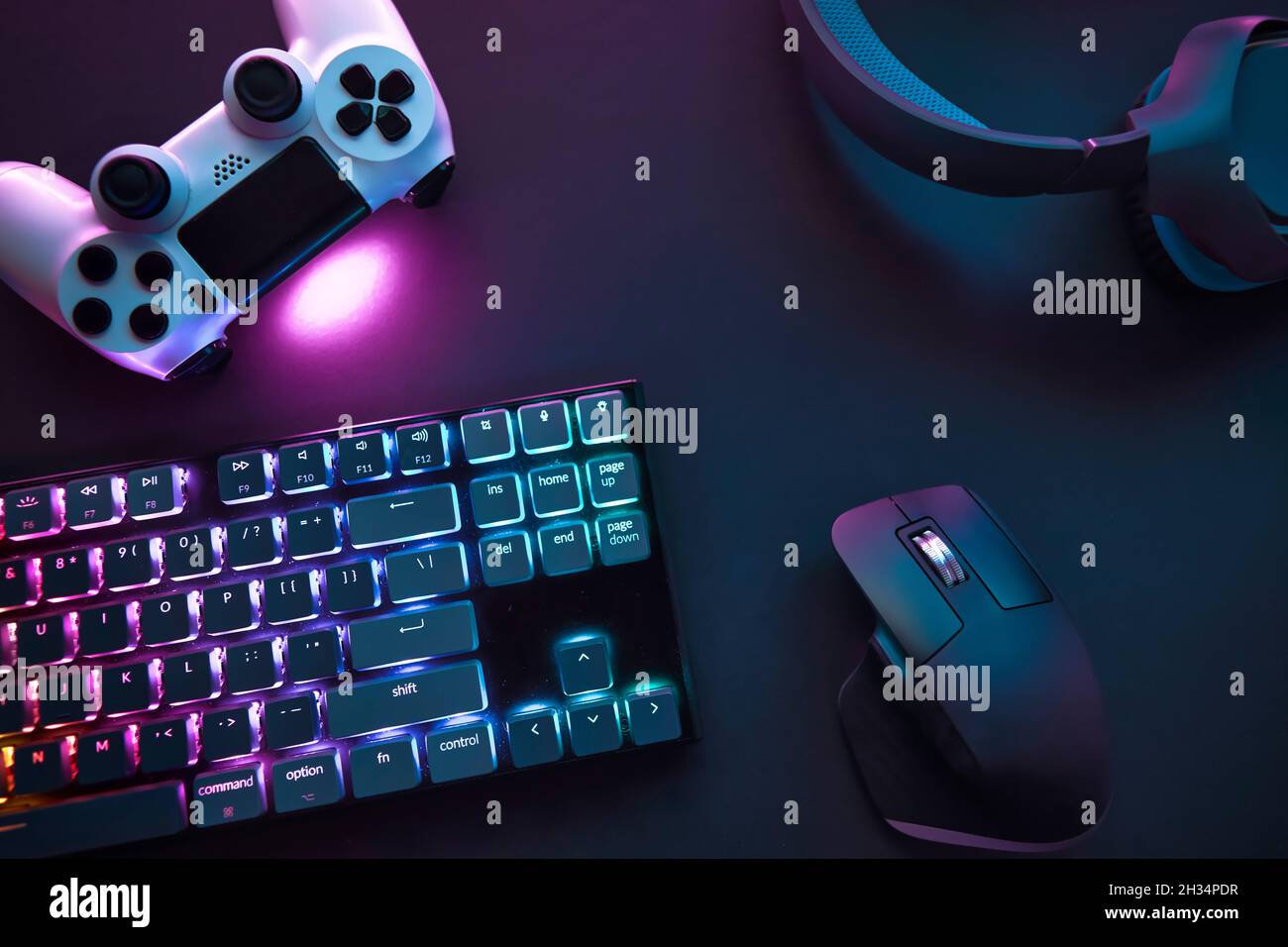 Vista dall'alto di vari accessori da gioco che si posano sul tavolo. Dispositivi illuminati a colori. Giochi di computer professionali, eport business e onl Foto Stock