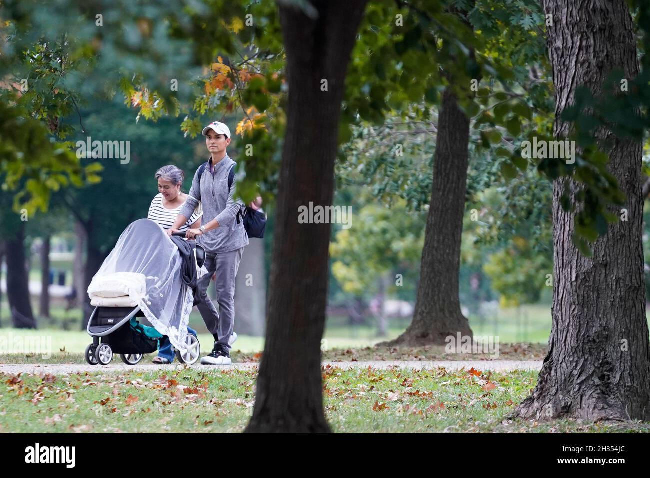 Washington, Stati Uniti. 25 ottobre 2021. Un uomo spinge un passeggino sul National Mall a Washington, DC, Stati Uniti, il 25 ottobre 2021. I consulenti della Food and Drug Administration (FDA) degli Stati Uniti sono previsti per un incontro chiave martedì sulla possibilità di raccomandare il vaccino Pfizer-BiONTech COVID-19 per i bambini di età compresa tra 5 e 11 anni, come gli esperti hanno previsto che i bambini più giovani saranno idonei per il vaccino all'inizio di novembre. Credit: Ting Shen/Xinhua/Alamy Live News Foto Stock