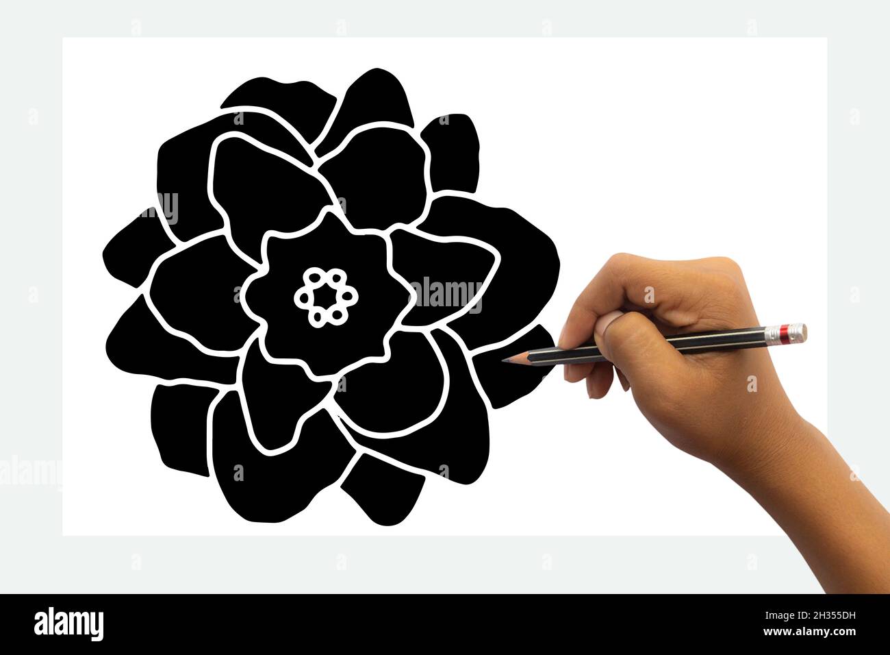 La mano del bambino è pronta per disegnare un fiore nero con una matita nera. Isolato su sfondo bianco del tavolo. Foto Stock