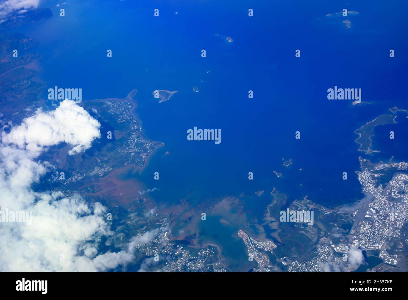 Vista aerea della Terra, dell'Oceano e della Terra dall'aeroplano sopra le nuvole Foto Stock