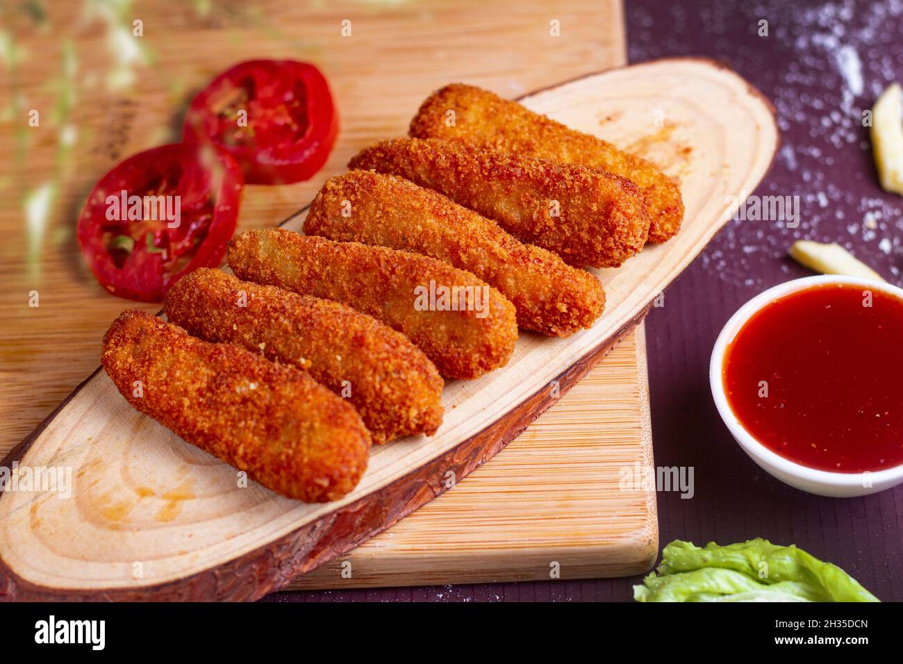 Dita di pollo fritte croccanti con Ketchup su tavola di legno Foto Stock