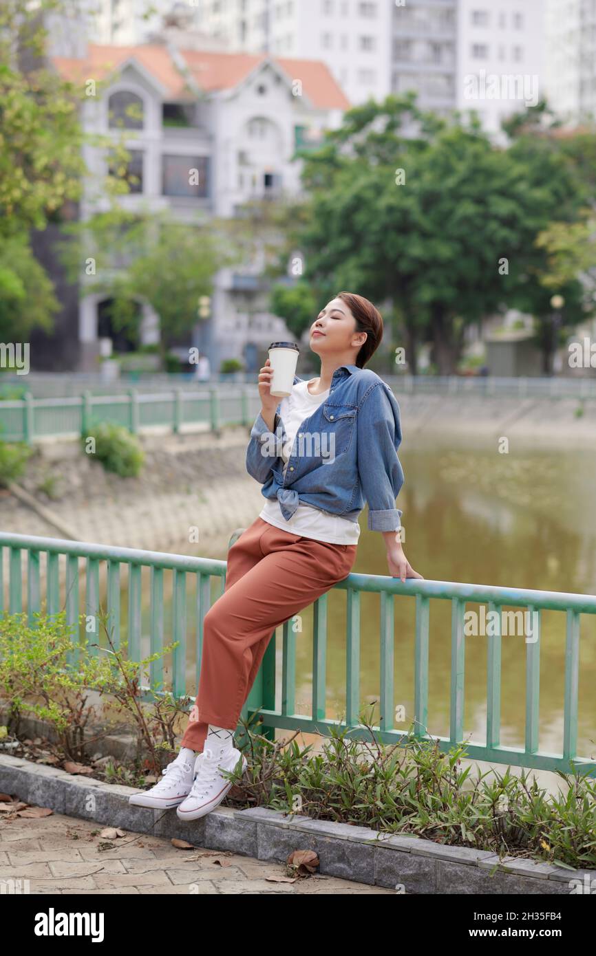 Ragazza modello hipster bere caffè sullo sfondo della città Foto Stock