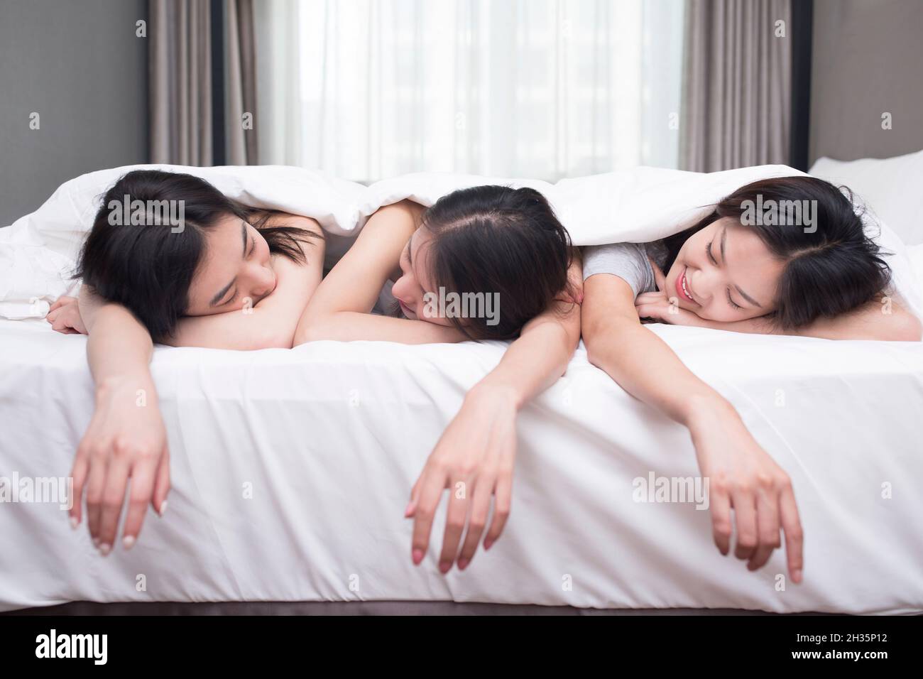 Tre migliori amici che riposano sul letto Foto Stock