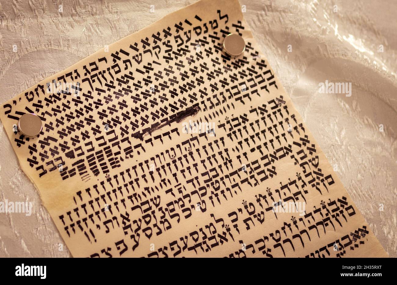 Lettere ebraiche scritte su pergamena, una scritta speciale di un rotolo Torah. (Al redattore - le lettere sono casuali senza significato) Foto Stock