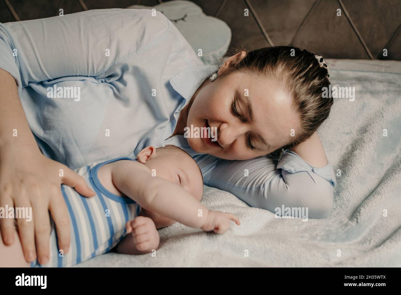 Madre e bambino neonato coccolarsi a letto Foto Stock