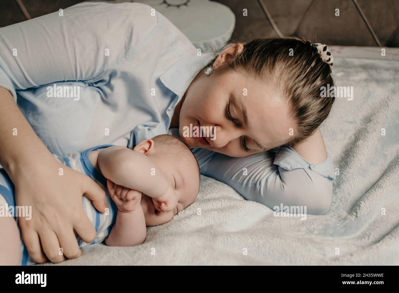 Madre e bambino neonato coccolarsi a letto Foto Stock