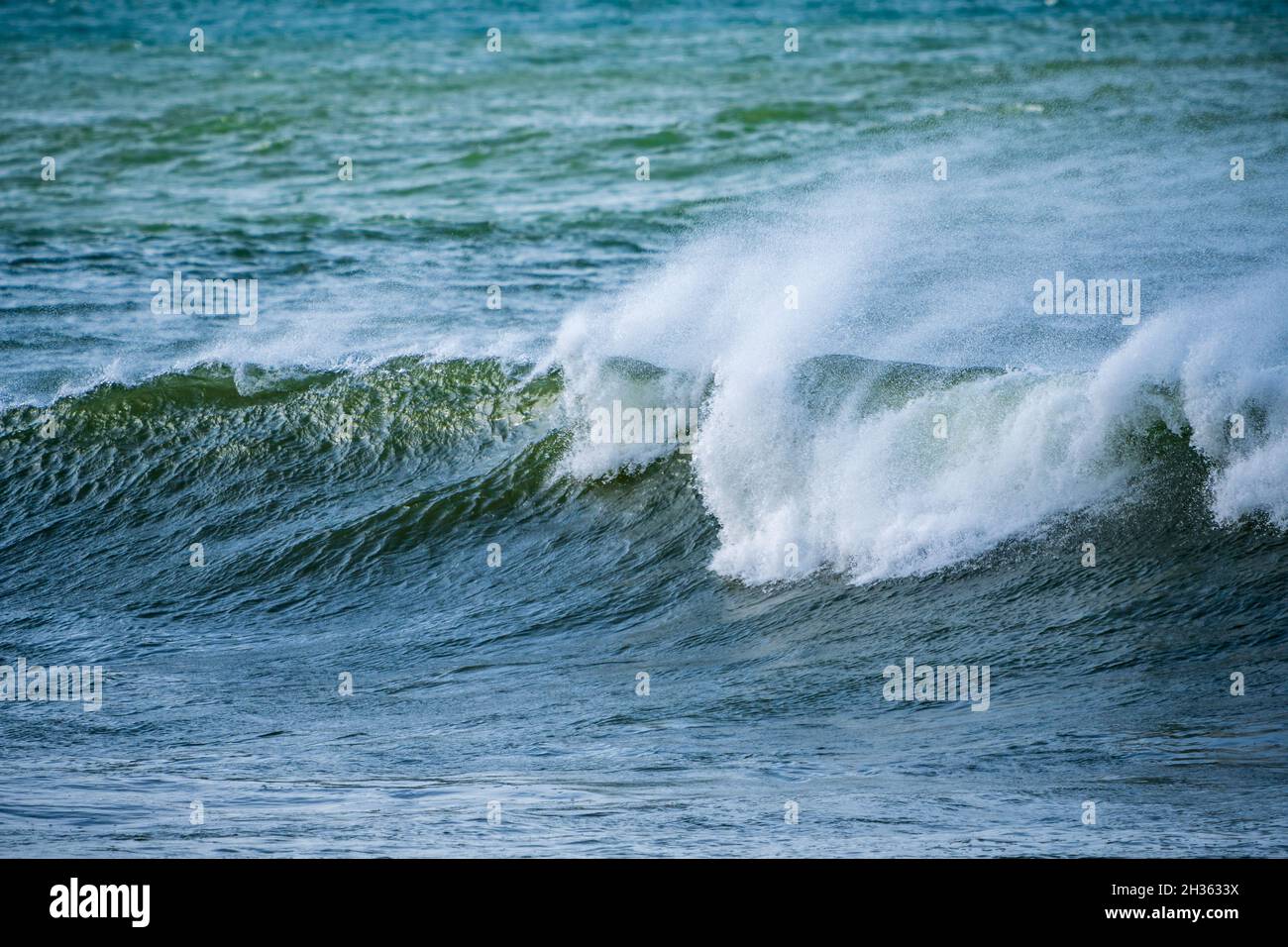 Belle onde oceaniche di prima mattina con spruzzi sono stati spazzati da forti venti. Hermanus. Whale Coast. Overberg. Capo Occidentale. Sudafrica Foto Stock