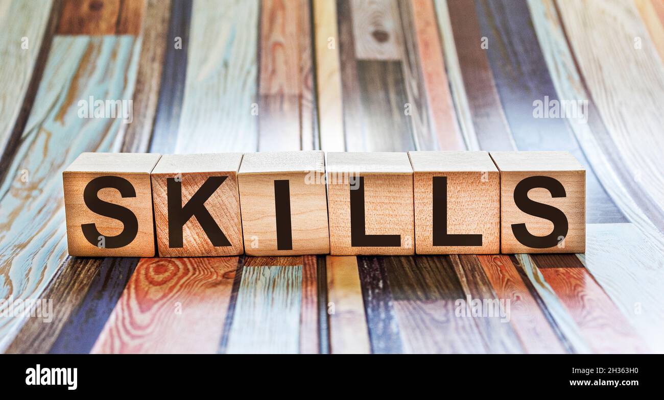 Blocchi di legno con abilità di testo su sfondo colorato Foto Stock