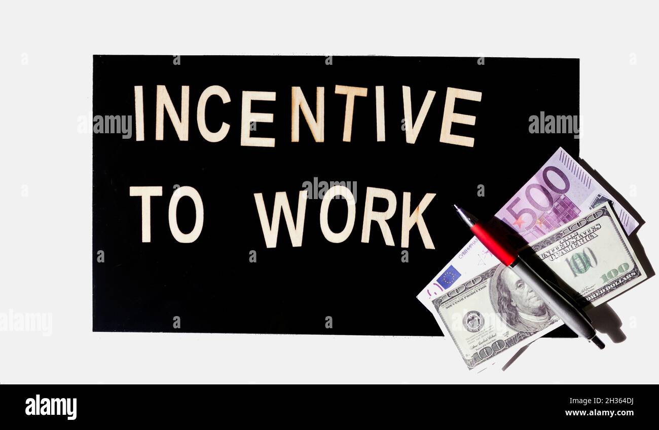 INCENTIVE TO WORK text è scritto su uno sfondo a specchio nero in lettere di legno. Foto Stock