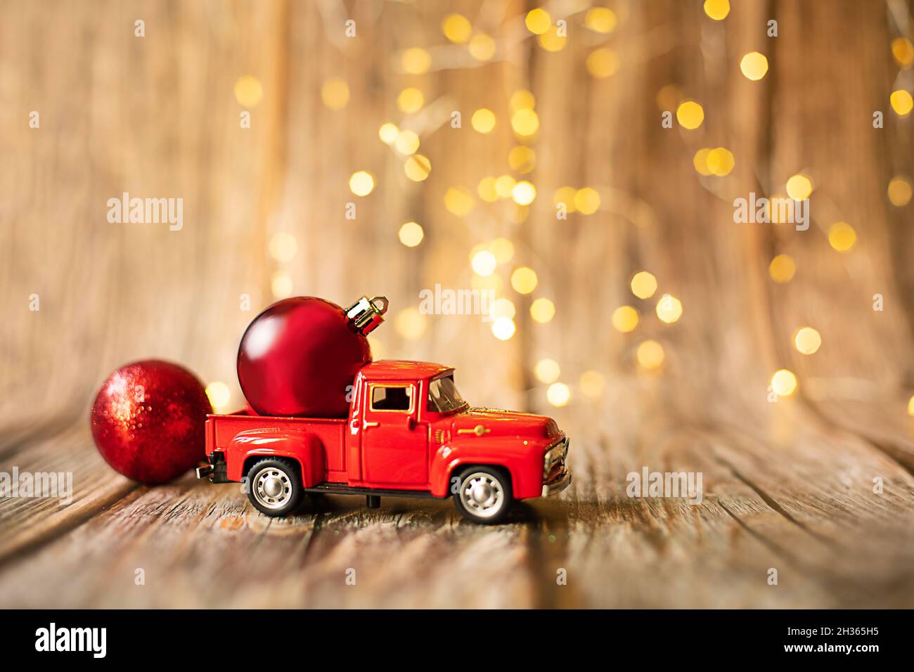auto in miniatura su sfondo di legno con luce di natale, decorazione giocattolo per le vacanze. Concetto - Vendita di Capodanno, shopping di Natale. Phot. Oggetto orizzontale Foto Stock