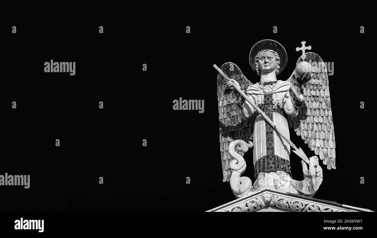 San Michele Arcangelo sconfigge il Drago, una statua medievale del XIII secolo sulla sommità della Chiesa di San Michele a Lucca (bianco e nero con copia spac Foto Stock