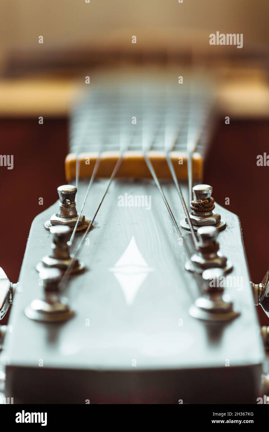 Pioli di sintonizzazione in metallo di una chitarra acustica primo piano. Foto Stock