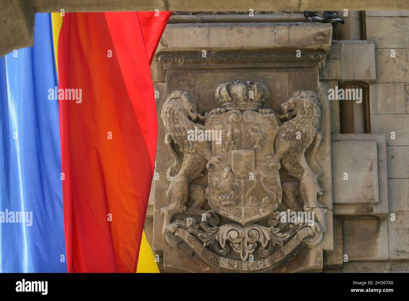 Bucarest, Romania, Agosto 23, 2009: lo stemma reale della Romania su l' Arco di Trionfo di Bucarest e la bandiera rumena. Foto Stock