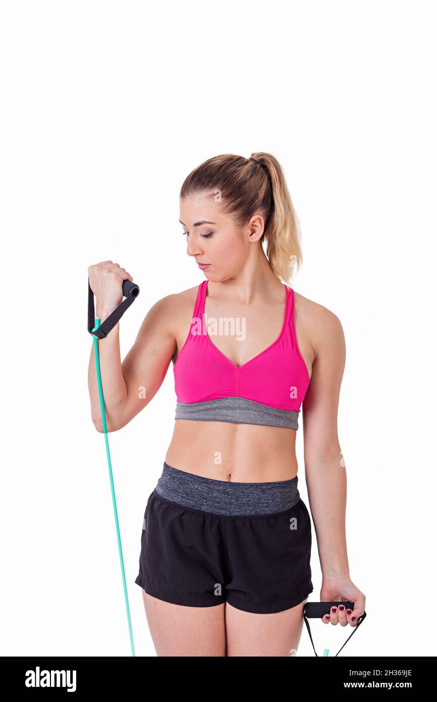 Giovane donna che fa esercizi di bicipite con fasce elastiche su sfondo bianco. Foto Stock