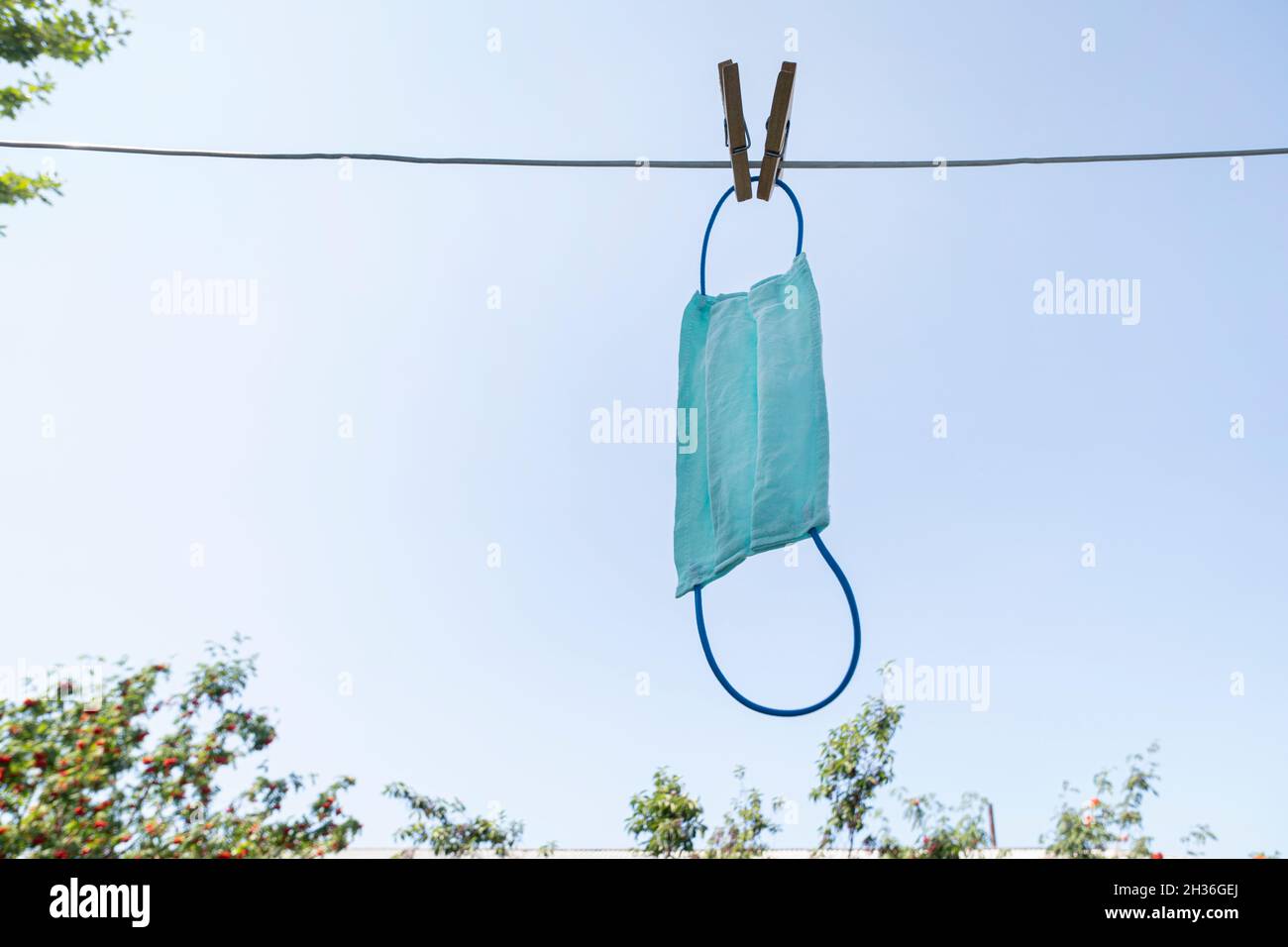 Lavaggio a mano della maschera di panno dopo un uso. Corona virus prevenzione viso di copertura pulizia a casa nel lavandino. Lavaggio la maschera usata. Foto Stock