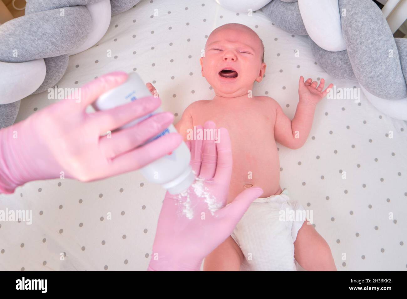 Il medico sta versando la polvere per il neonato. Infermiere dermatologo in uniforme Foto Stock