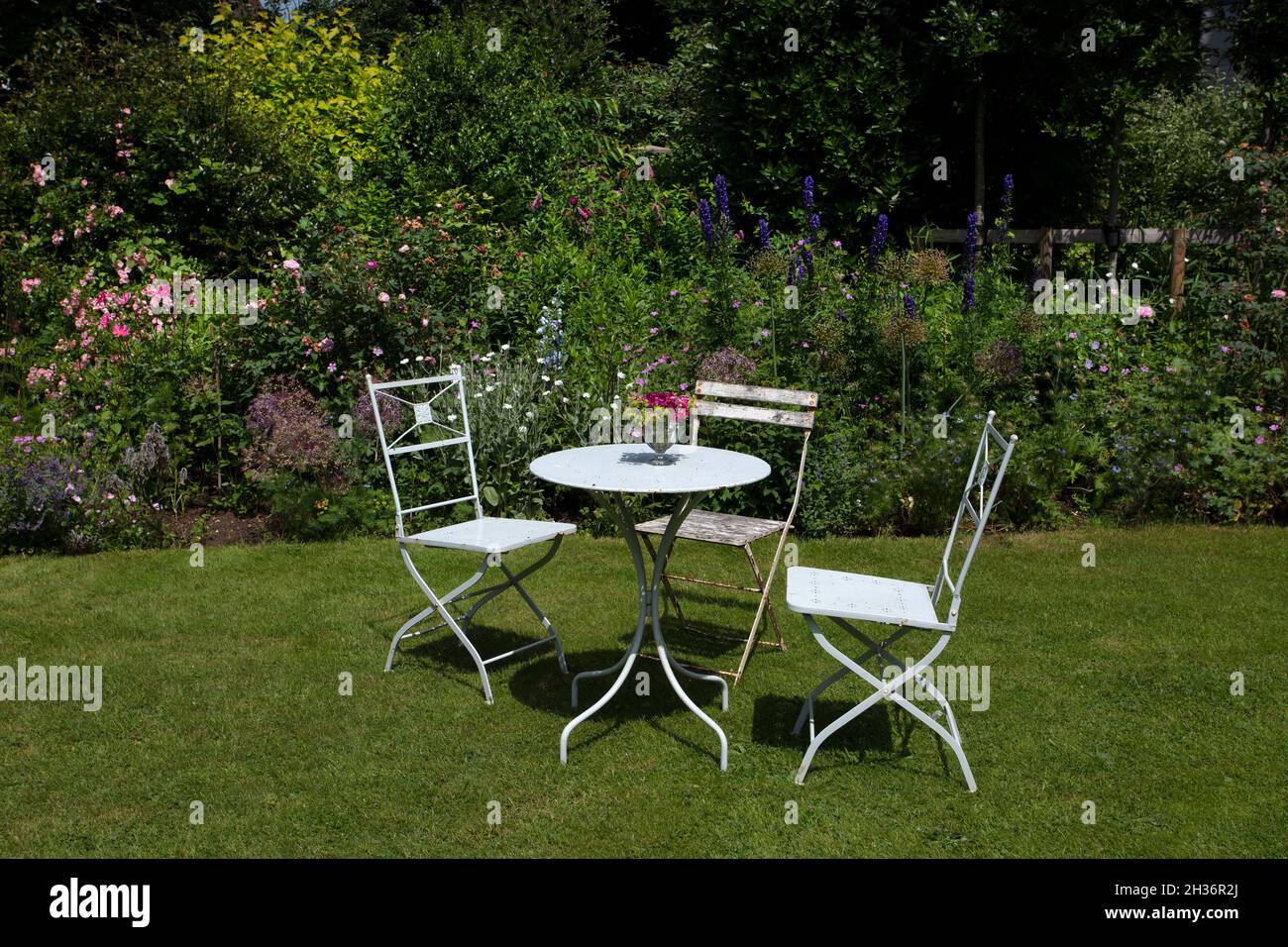 Posti a sedere in Metal Garden nel giardino estivo inglese, Oxfordshire, Inghilterra Foto Stock