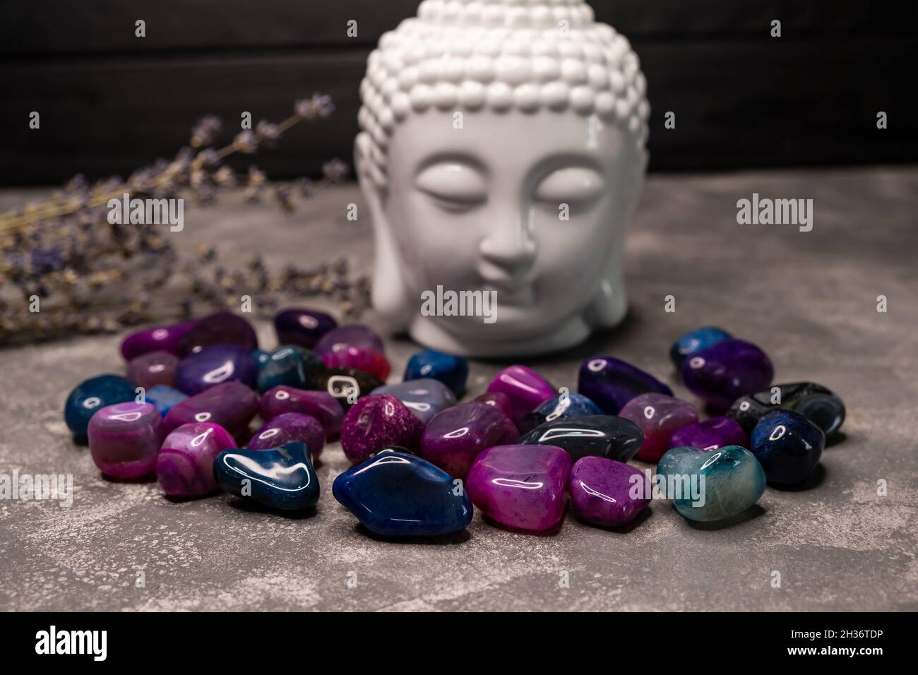 Testa di Buddha con cristalli. Equilibrio e flusso di energia calmo in casa. Foto Stock