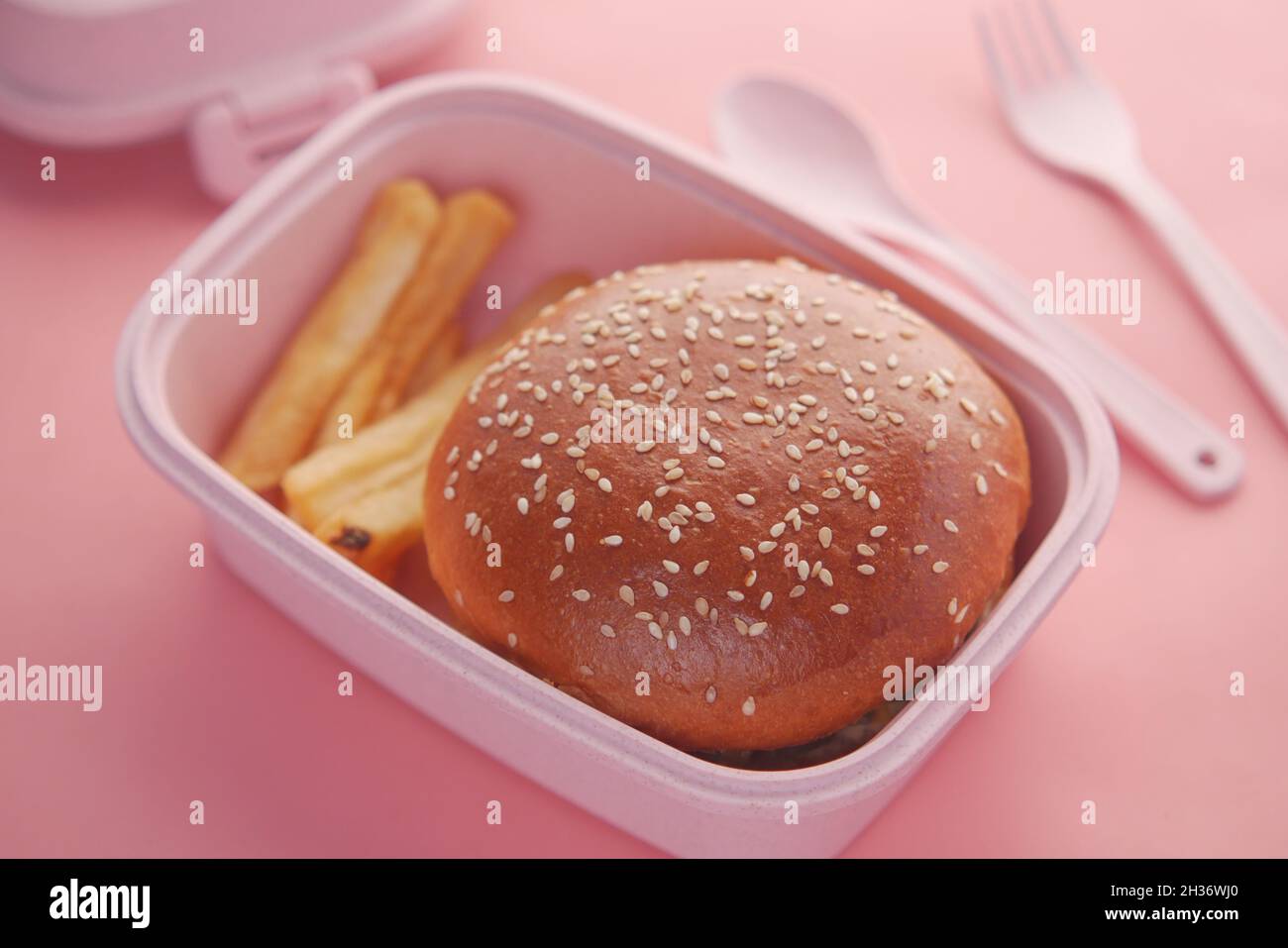 hamburger di manzo e amico francese in un pranzo al sacco su sfondo rosa Foto Stock