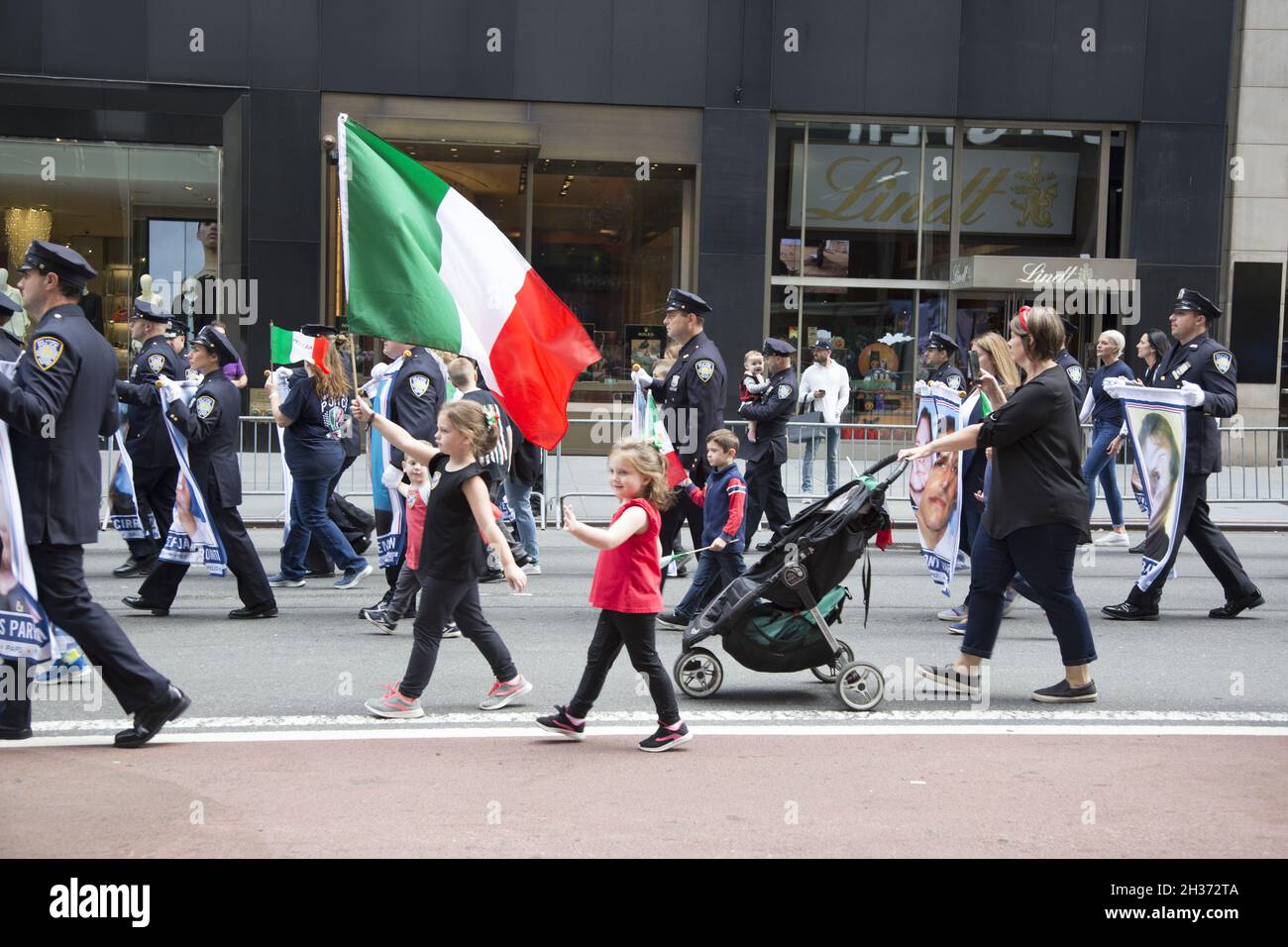 Il bambino porta con orgoglio la bandiera italiana che marciò con un gruppo di polizia alla Columbus Day Parade a New York City. Foto Stock