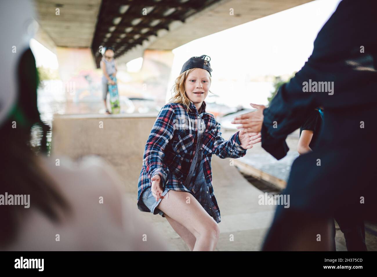 Amici skateboarder fare trucchi mentre si rotola su half pipe in skate Park. Sport per bambini e attività all'aperto nel parco estremo. I bambini felici su ska Foto Stock