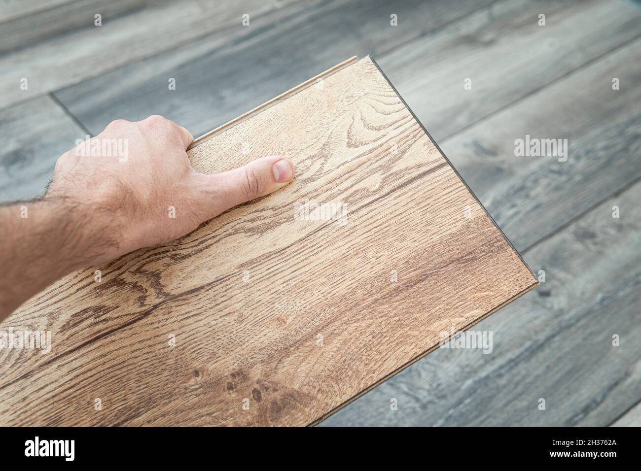 Pavimento in parquet laminato in legno, scelta di colori con vista dall'alto. Parquet in mano al maestro. Foto Stock