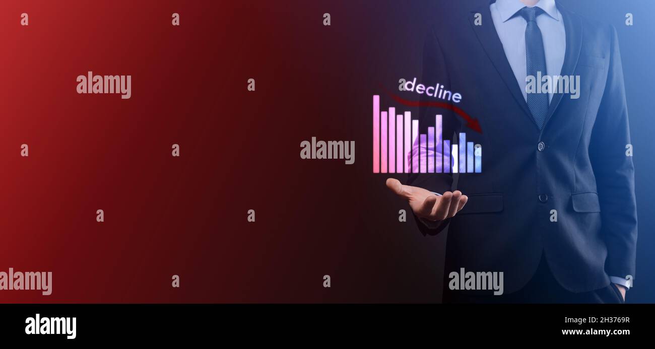 Uomo d'affari che tiene i grafici olografici e stock.declinare, diminuire, giù, cadere. Statistica aziendale. Carriera, soldi, concetto di successo. Regressione, critico Foto Stock