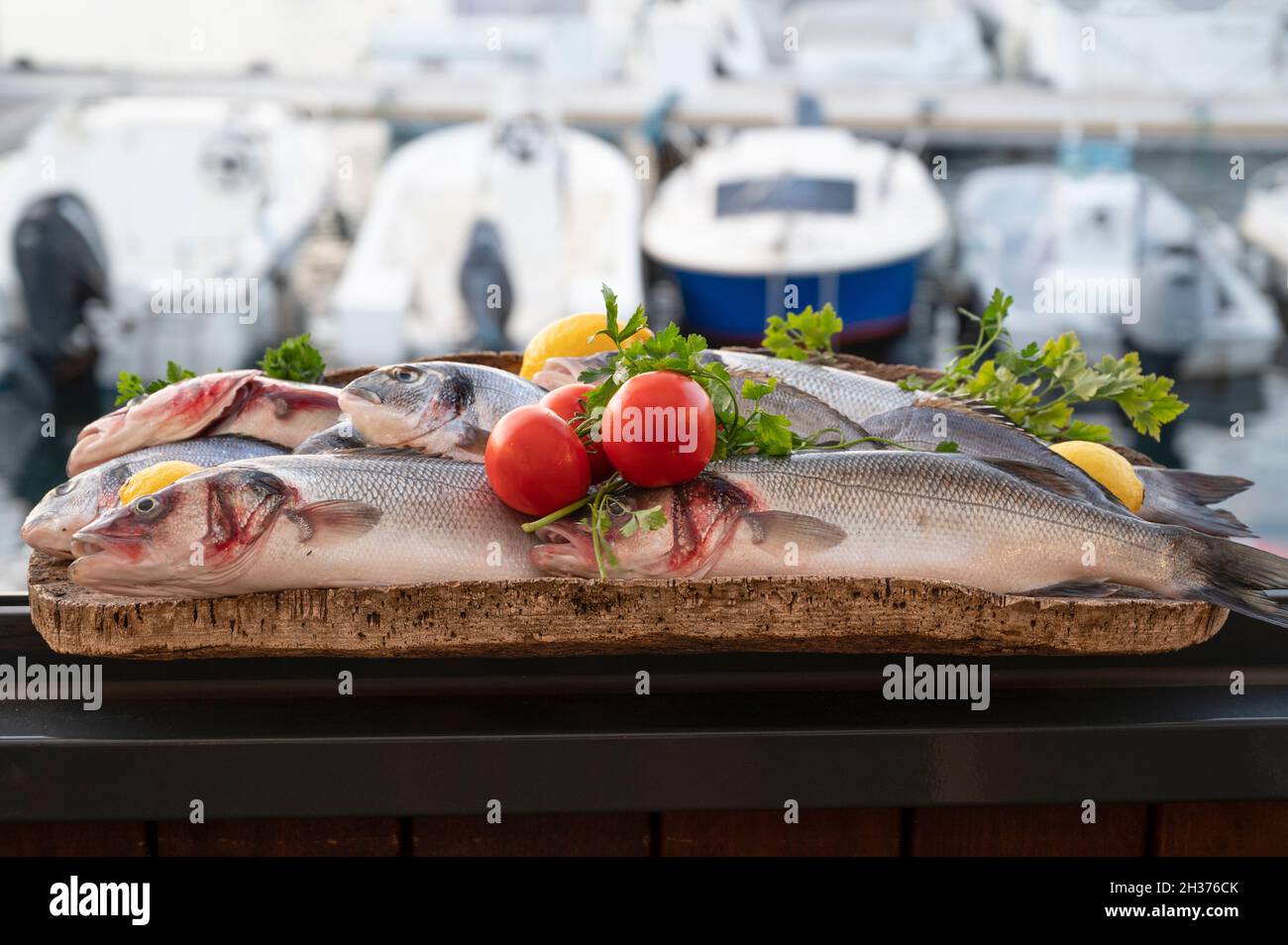 Un piatto di pesce fresco presentato dal ristorante Grand Bar des Goudes a Les Goudes, Marsiglia, con vista sul porticciolo del quartiere Foto Stock