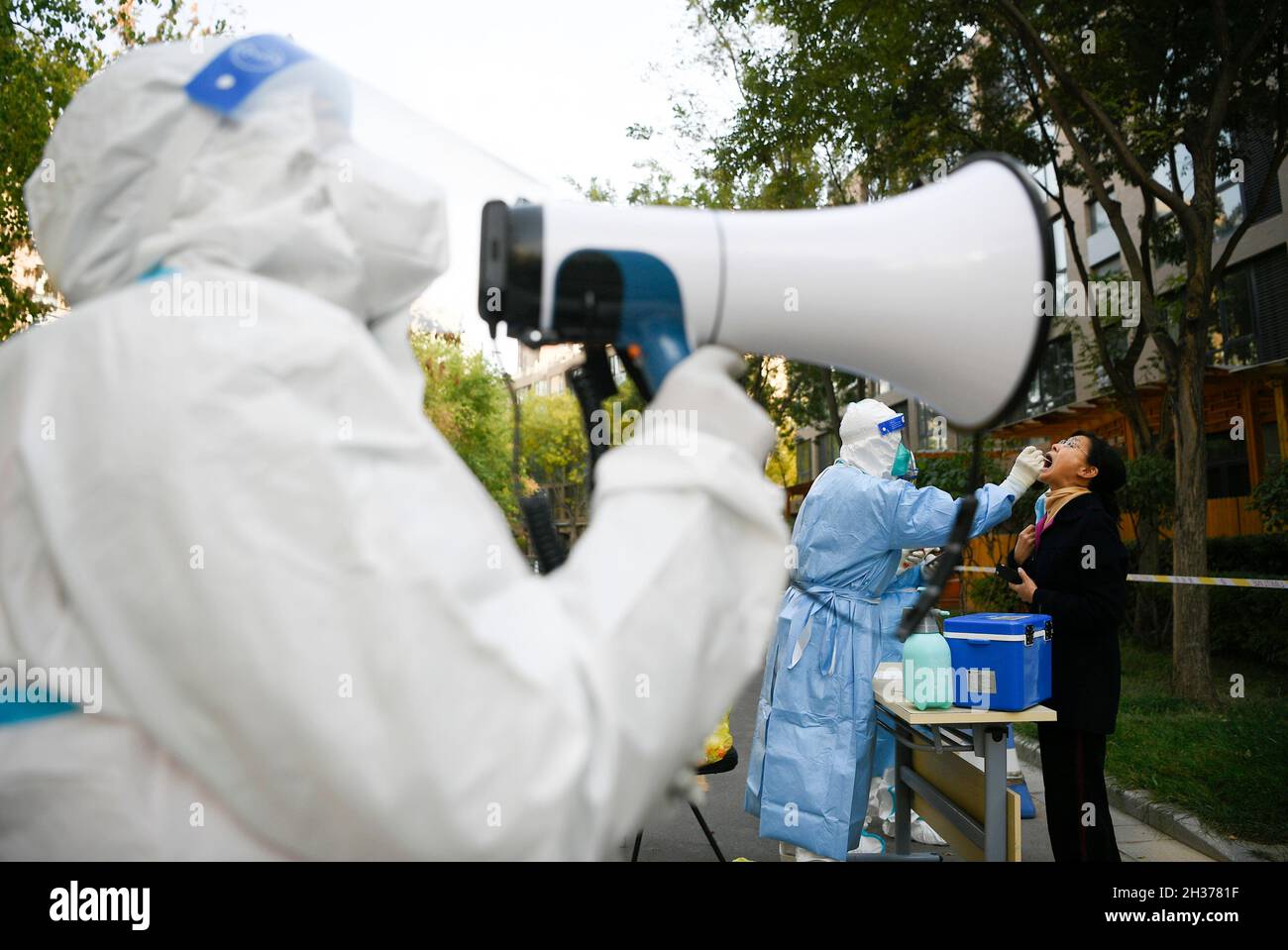 Yinchuan, la regione autonoma cinese di Ningxia Hui. 24 ottobre 2021. Gli operatori sanitari conducono test sugli acidi nucleici per i residenti di un composto residenziale bloccato a causa della rinascita COVID-19 nel distretto di Jinfeng, Yinchuan, regione autonoma di Ningxia Hui, nella Cina nord-occidentale, 24 ottobre 2021. Credit: Wang Peng/Xinhua/Alamy Live News Foto Stock
