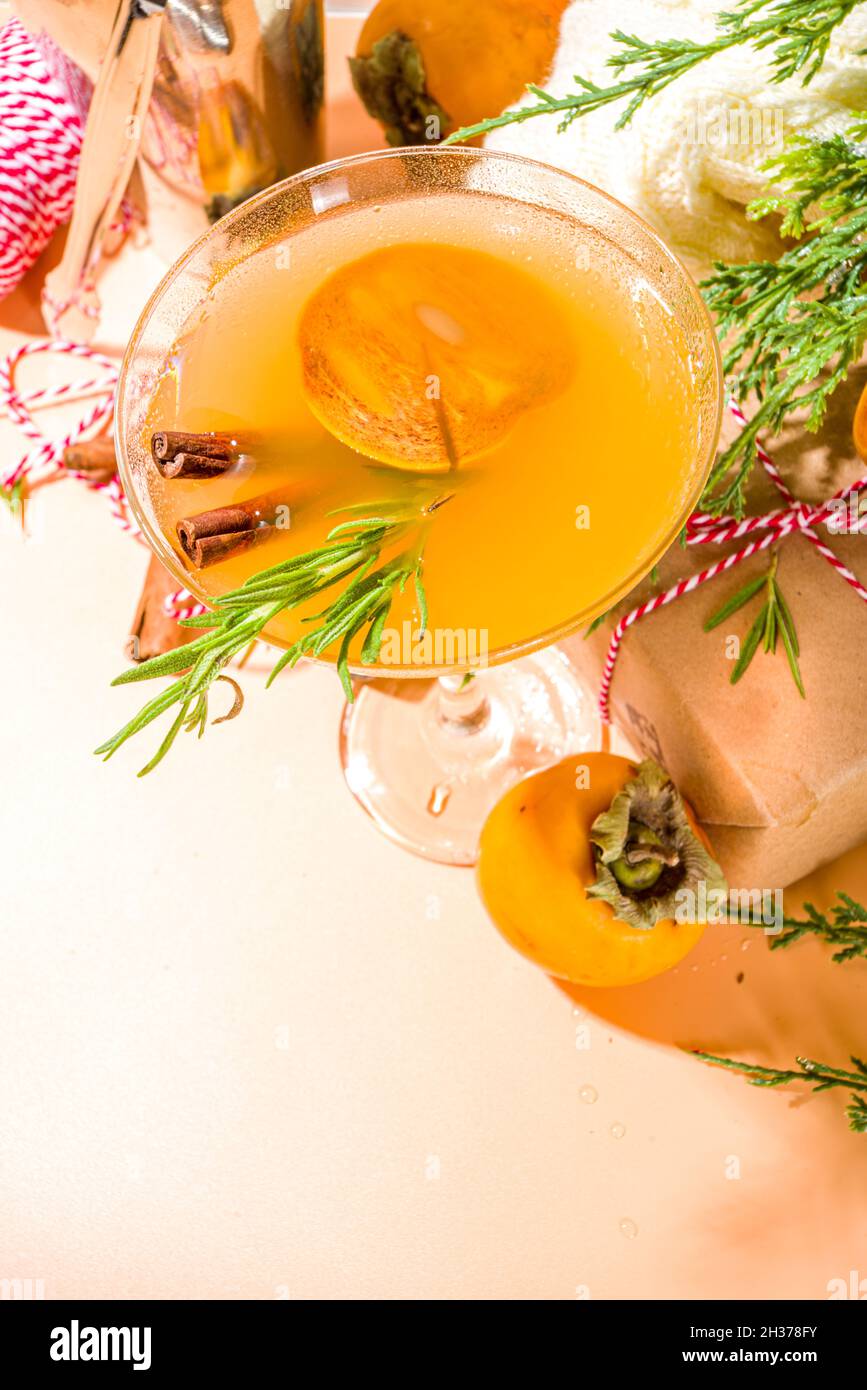 Alcool boozy alcool drink, autunno inverno persimmon margarita cocktail, con frutta fresca di persimmon e rosmarino Foto Stock