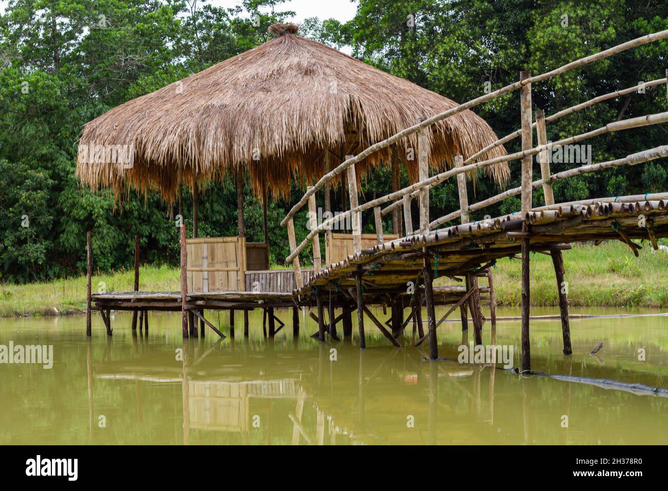 Gazebo strutturato in legno e bambù nel mezzo del lago con vista naturale per rilassarsi e godersi il tempo di relax Foto Stock