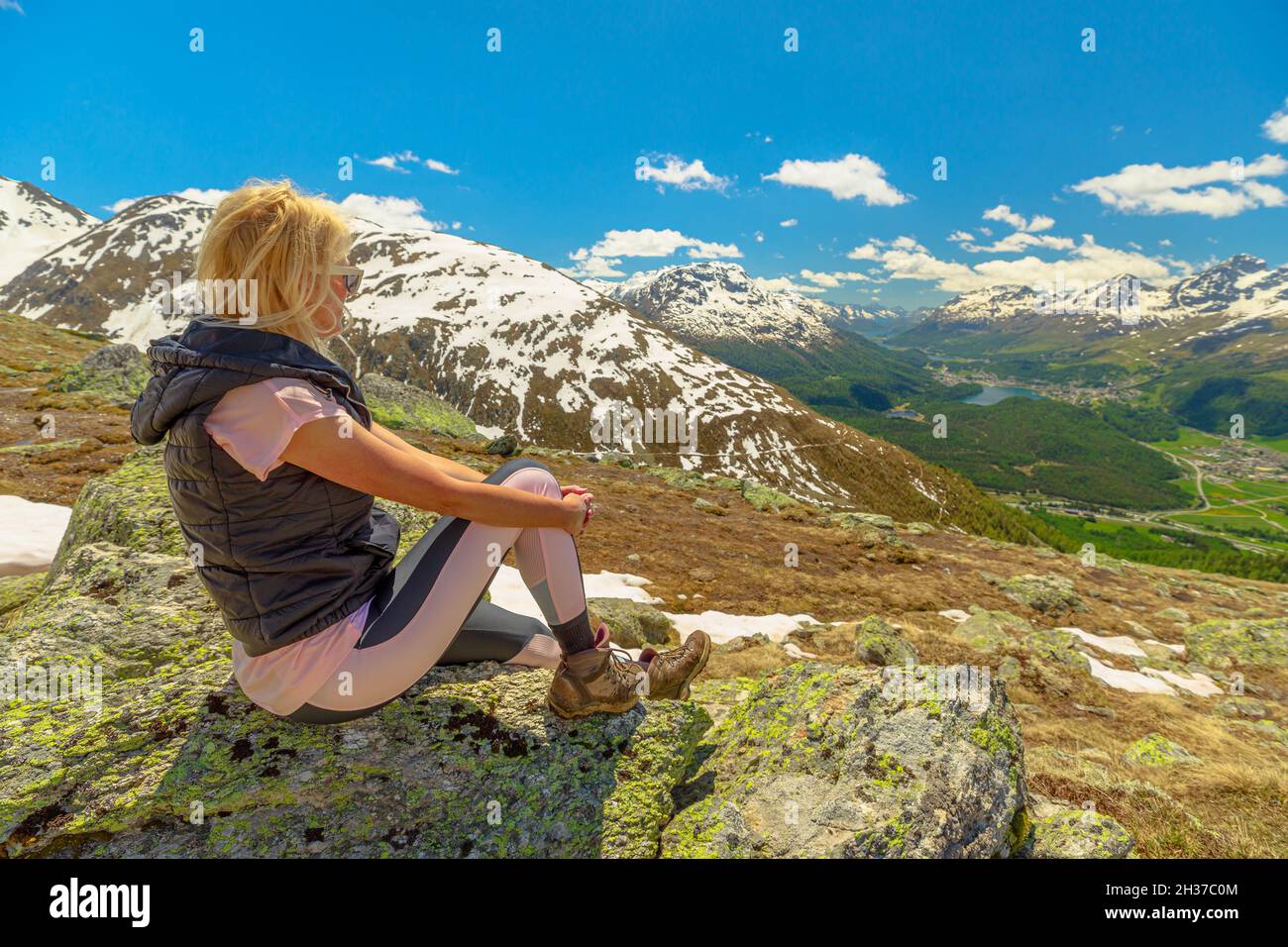 Donna che riposa sulla cima del monte Muottas Muragl in Svizzera. Luogo popolare per escursioni in montagna nel Cantone di Graubunden in Svizzera. Foto Stock