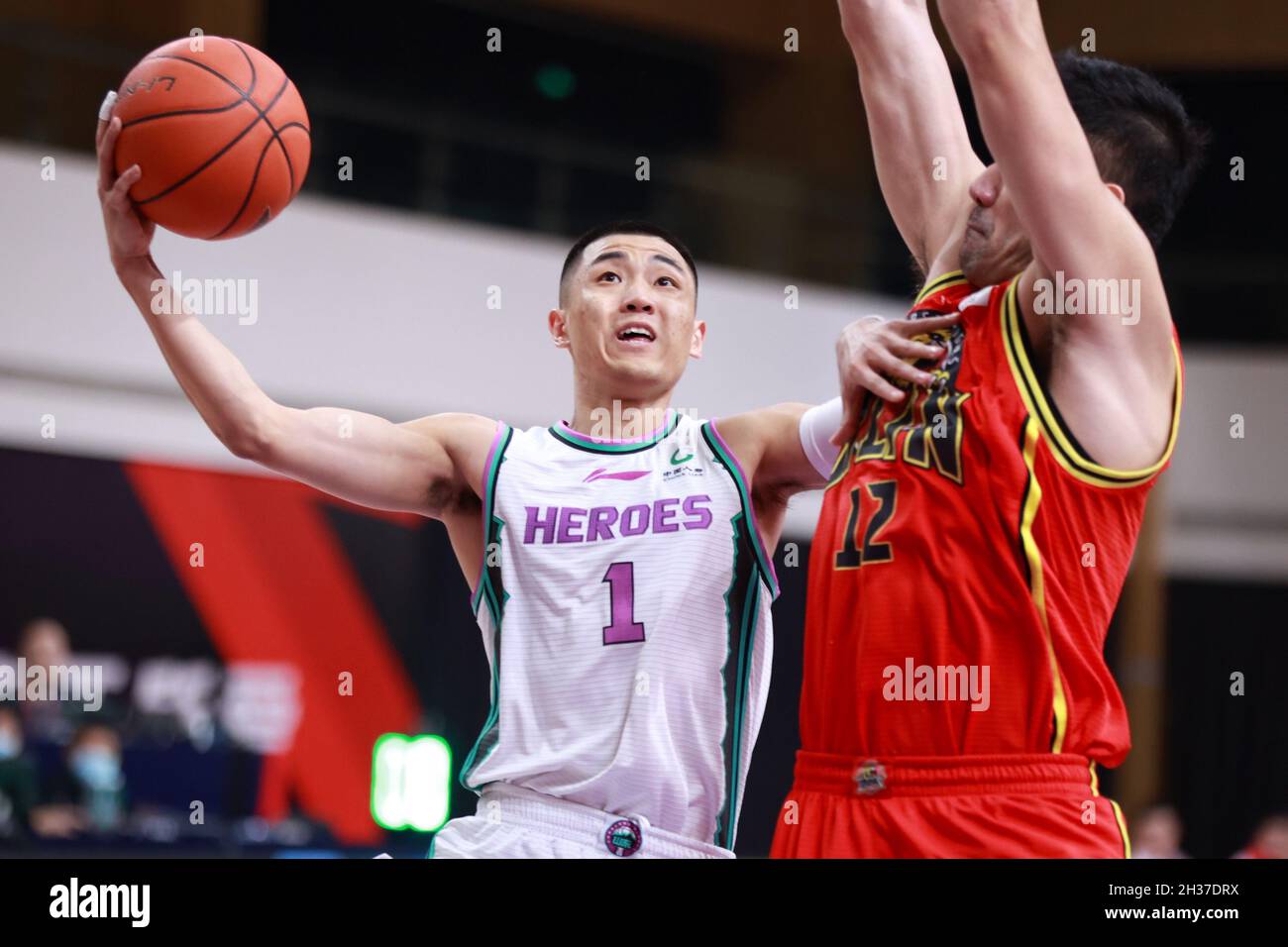 Zhuji, provincia cinese di Zhejiang. 26 ottobre 2021. Gao Shiyan (L) di Shandong Heros va per un lay-up durante la quinta partita di round tra Shandong Heros e Jilin Northeast Tigers alla stagione 2021-2022 della lega cinese di basket Association (CBA) a Zhuji, la provincia di Zhejiang della Cina orientale, il 26 ottobre 2021. Credit: Liu Xu/Xinhua/Alamy Live News Foto Stock