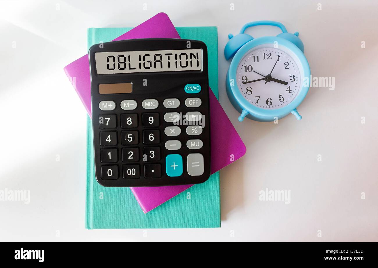 I notepad colorati, la sveglia e la calcolatrice CON obbligo di testo si trovano su uno sfondo bianco. Foto Stock
