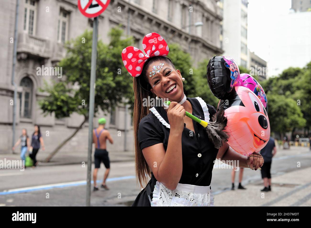 Brasile – 22 febbraio 2020: Reveler vestito come governante pulisce una mongolfiera della testa di Minnie durante una sfilata di strada di Carnevale tenutasi a Rio de Janeiro. Foto Stock