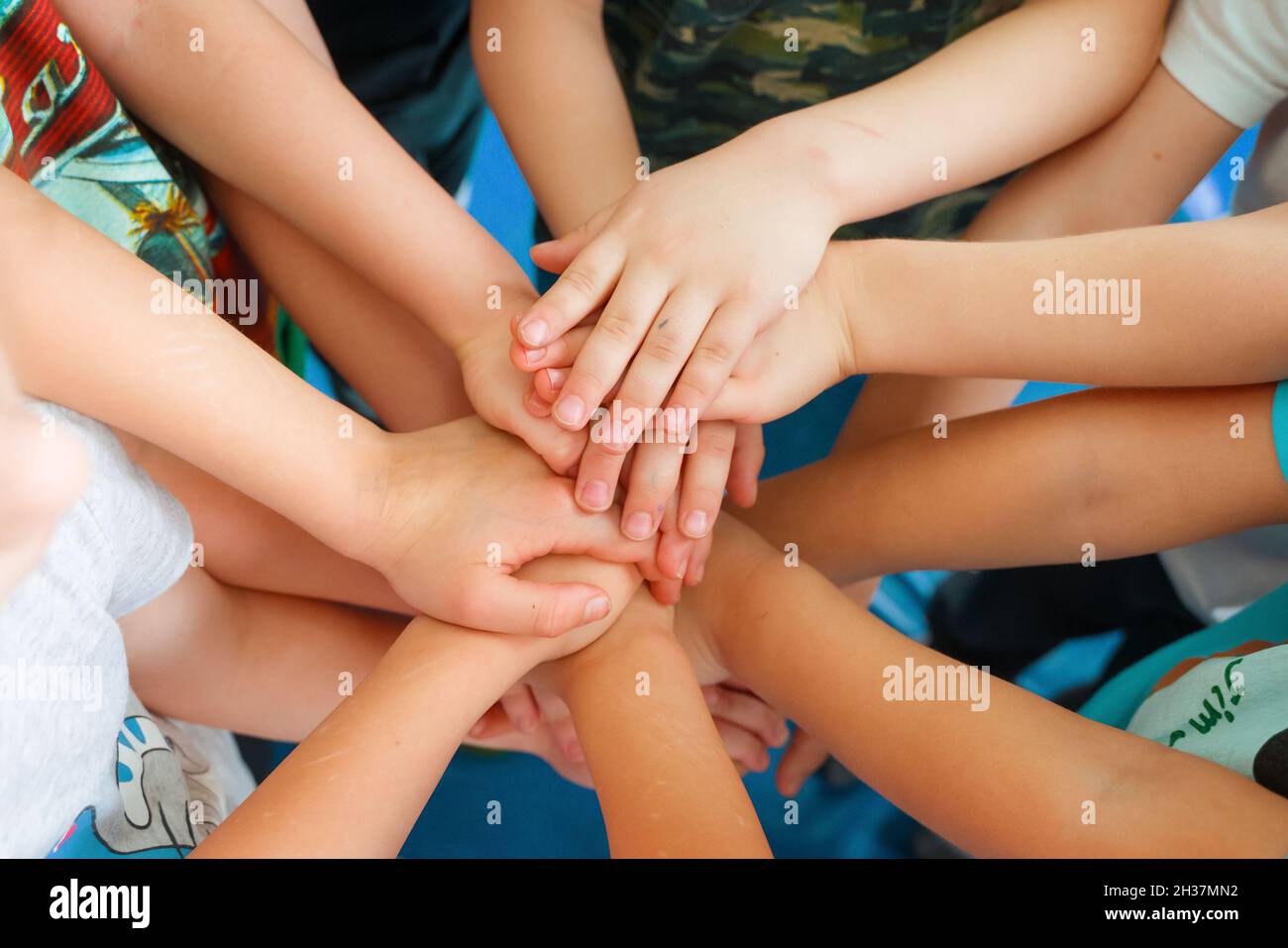 Team building. Mani dei bambini. Attività di gruppo per bambini. Il concetto di raggiungere un obiettivo comune in un team. Foto Stock