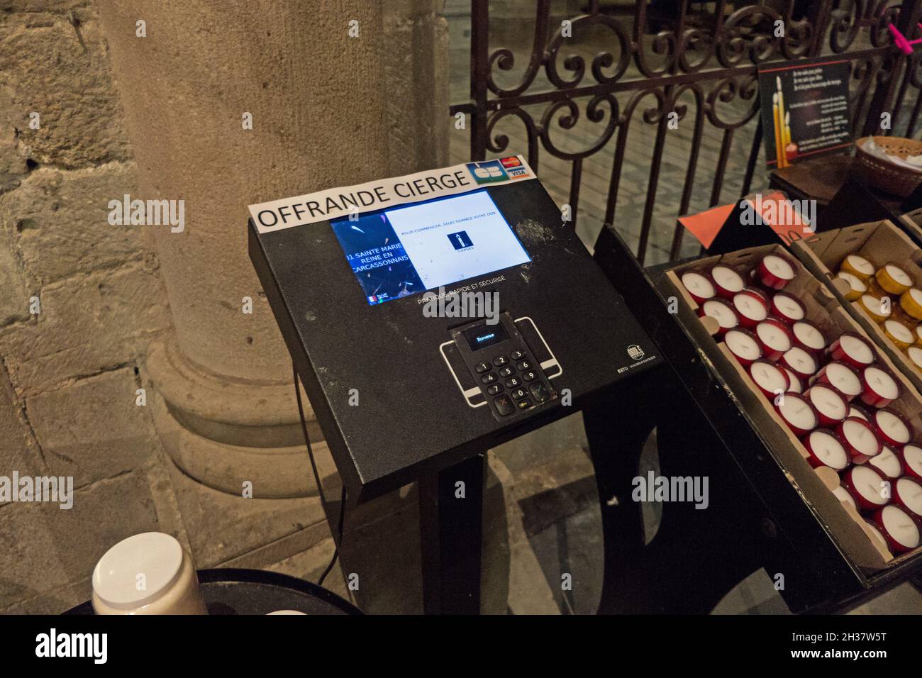 Terminale POS con carta di credito per offerte e candele a Carcassonne,  famosa città francese con cittadella medievale. Interno della chiesa  cattolica in Occitanie Foto stock - Alamy