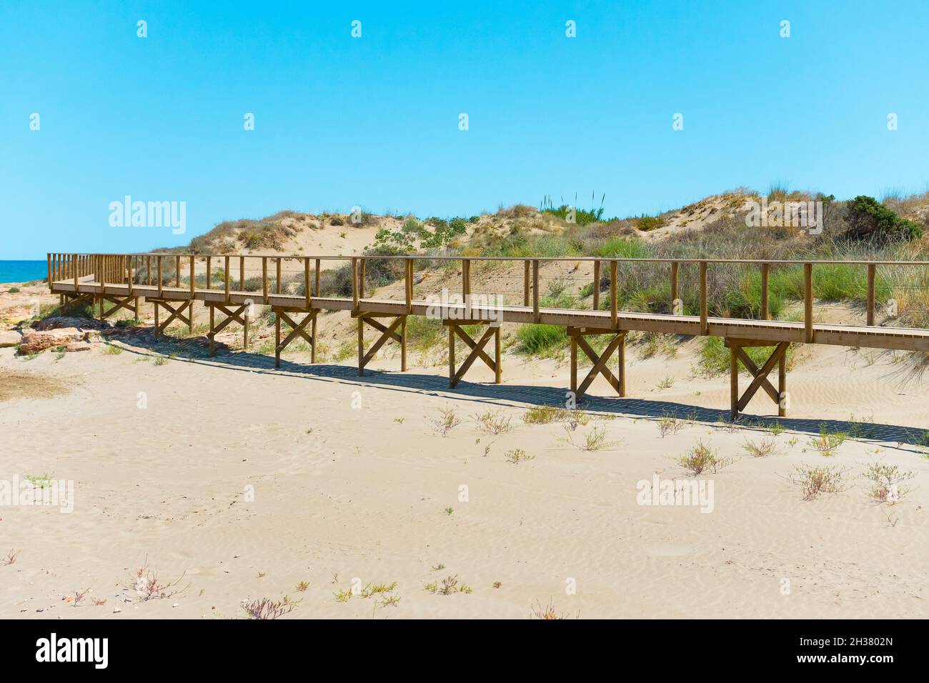 Passerella in legno sulla spiaggia con prateria di sabbia Foto Stock