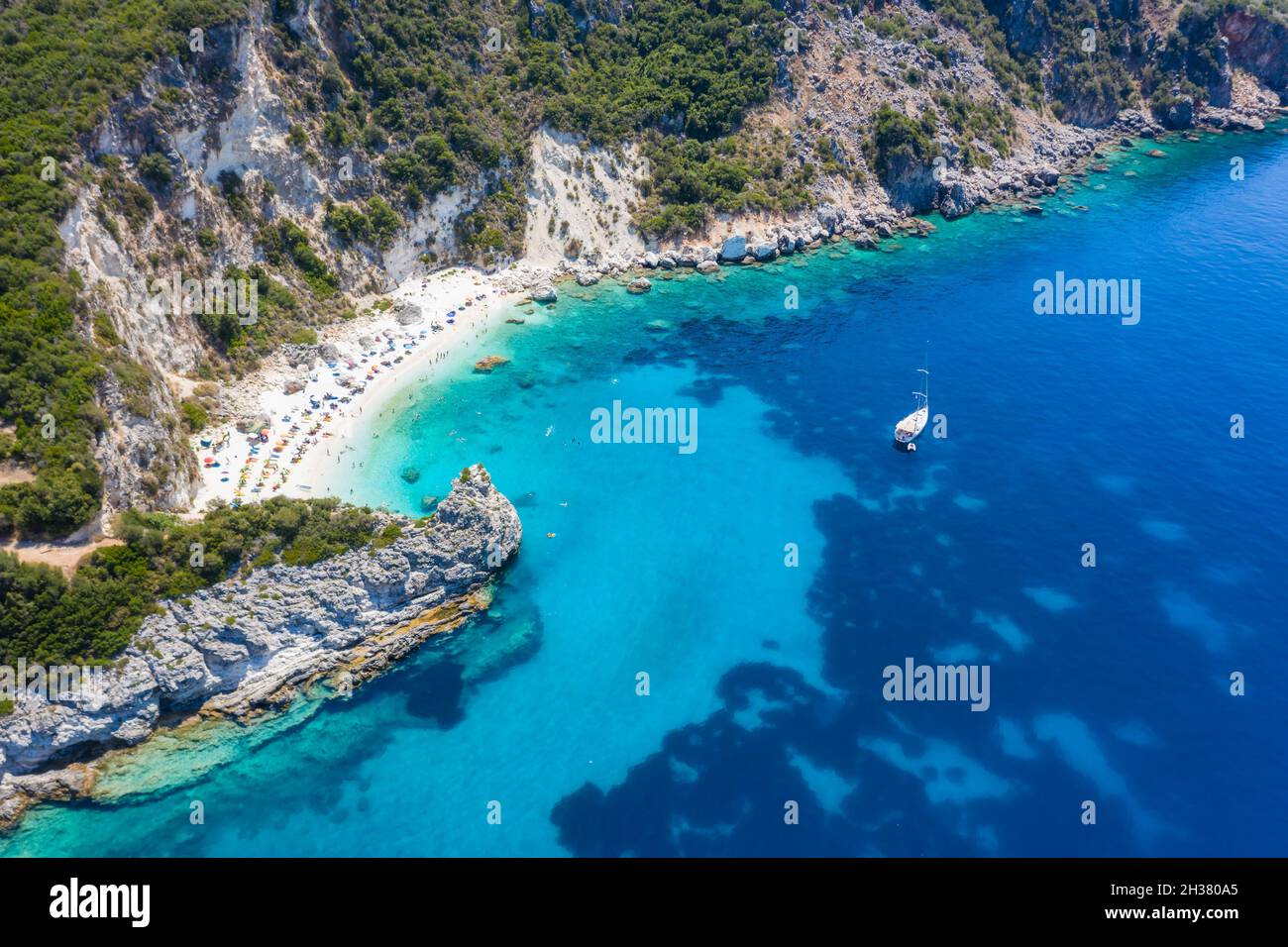 Foto aerea del drone del paradiso iconico spiaggia sabbiosa di Agiofili vicino al porto di Vasiliki con mare cristallino smeraldo e barche a vela ancorate, Lefkada Foto Stock