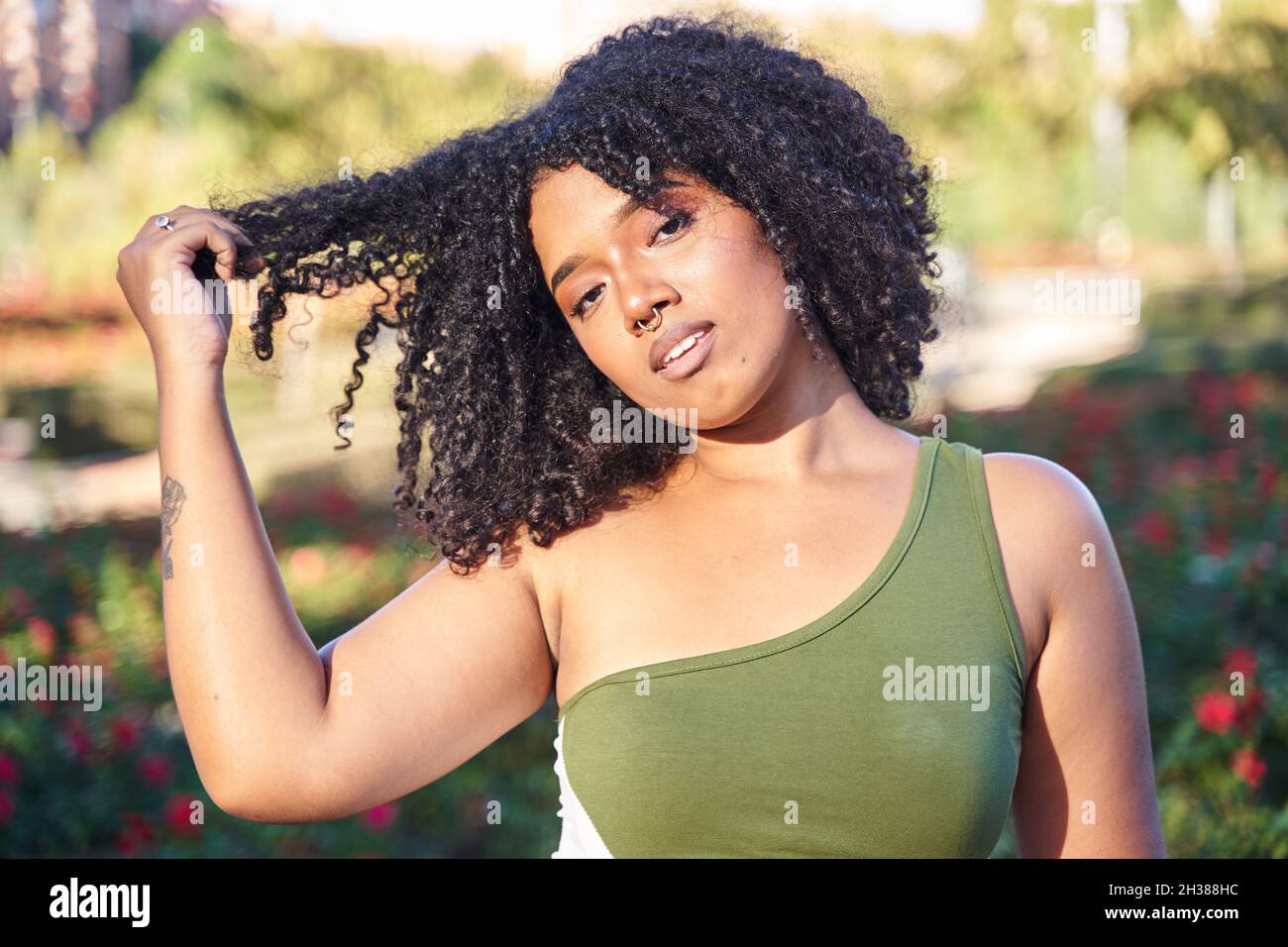 giovane donna che tira i capelli ricci con la mano Foto Stock