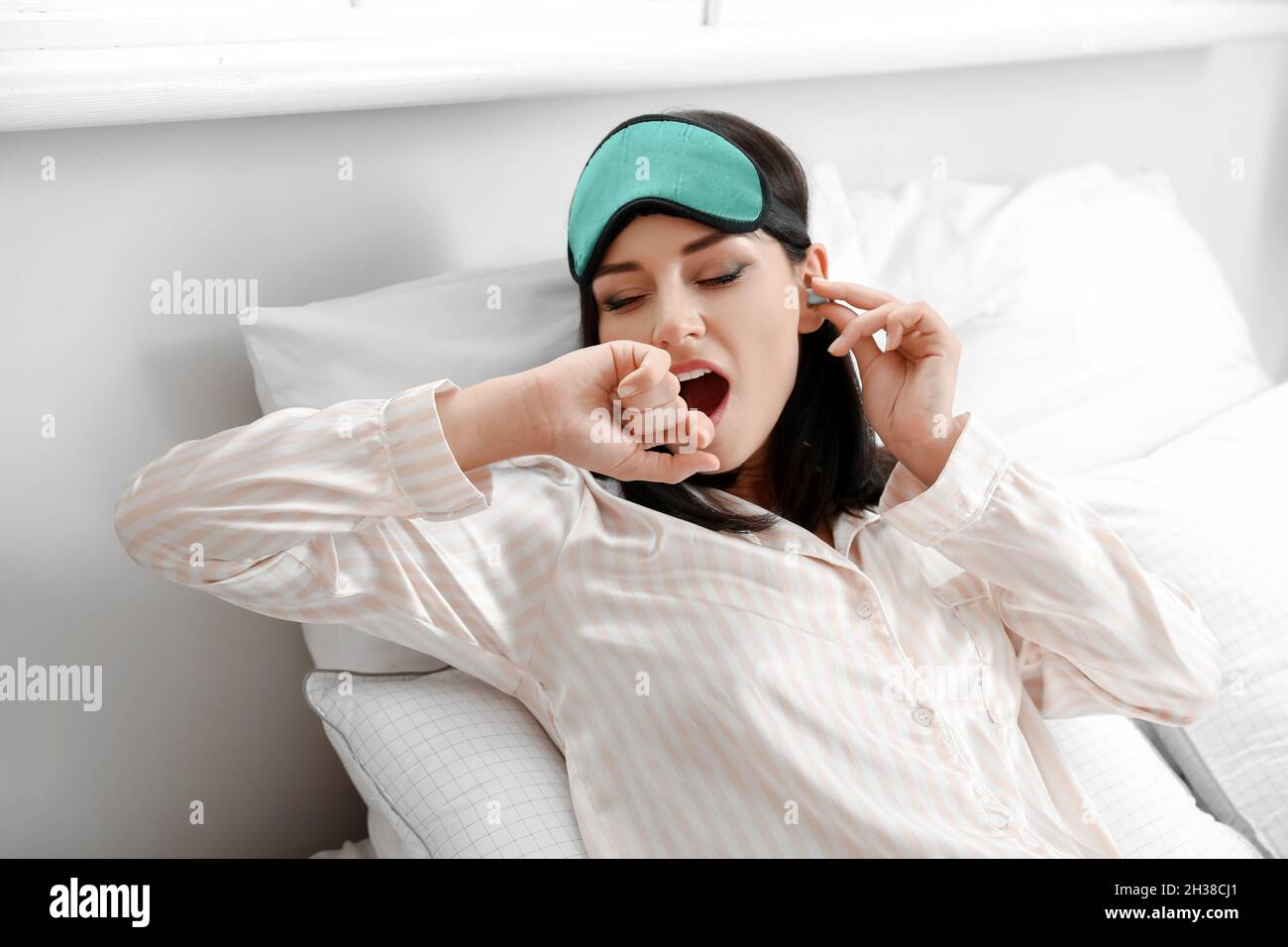 Giovane donna con tappi per orecchie che dorme a letto Foto stock - Alamy