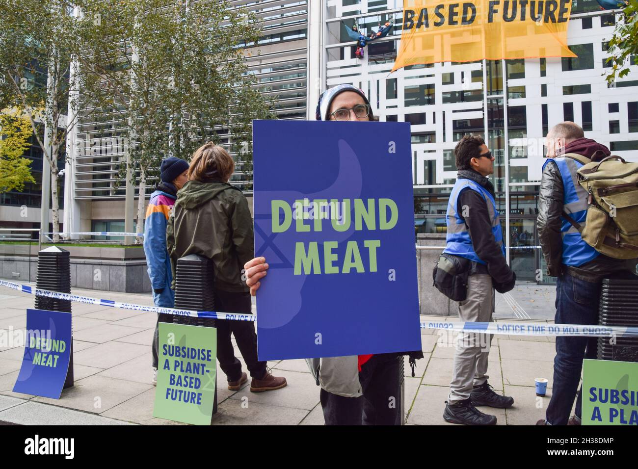 Londra, Regno Unito. 26 ottobre 2021. Un attivista tiene un cartello "Defund Meat" durante la dimostrazione.gli attivisti della ribellione animale hanno scalato l'edificio degli uffici domestici a Westminster, che include il Dipartimento per l'ambiente, l'alimentazione e gli affari rurali (Defra), chiedendo al governo britannico di smettere di sovvenzionare l'industria della carne e di investire in un futuro basato su piante. Credit: SOPA Images Limited/Alamy Live News Foto Stock